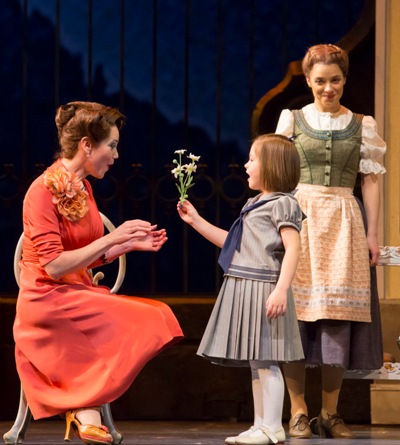 Baroness Schraeder (Elizabeth Futral) accepts a flower from Gretl (Nicole Scimeca) as Maria (Jenn Gambatese) beams proudly. Sound of Music Lyric Opera Chicago 2013 (Todd Rosenberg)