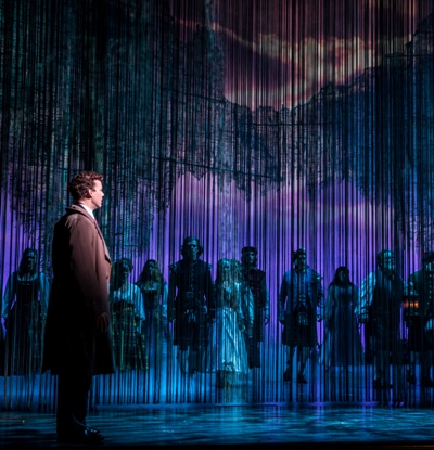 Tommy Albright (Kevin Earley) gazes upon the people of Brigadoon. Kevin Depinet's stage design depicts a town that lives for a day, then diesappears for 100 years. (Goodman Theatre, photo by Liz Lauren)